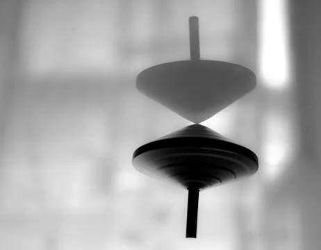 Spinning top in action on a mirror surface with sense of no gravity Stock Photos