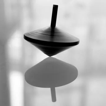 Spinning top in action on a mirror surface Stock Photos