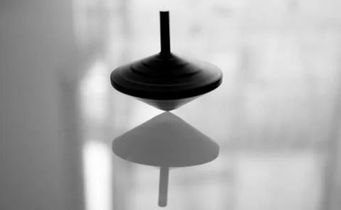 Spinning top in action on a mirror surface Stock Photos