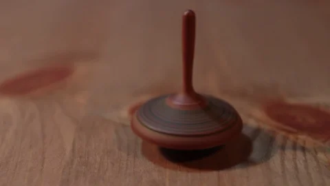 A spinning top turns over the table Stock Footage 117429499
