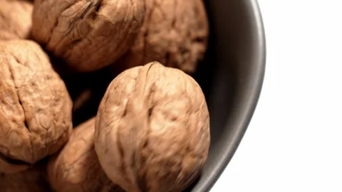 A spinning walnut falling into a bowl Stock Footage 330420751