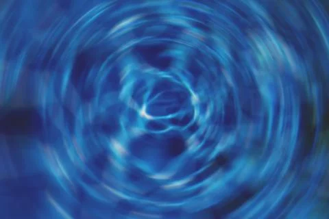 Spinning water whirlpool effect on the surface of cool blue water in natural Stock Photos