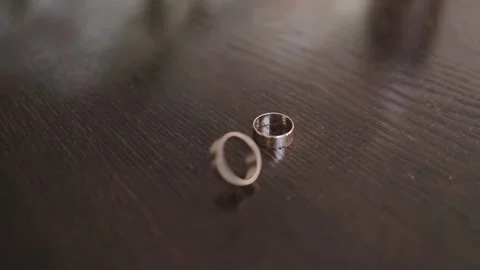 Spinning wedding rings, slow motion of rotating rings, close up dolly shot of Stock Footage 131337036