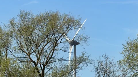 Spinning wind turbine behind bare trees detail Stock Footage 332353322