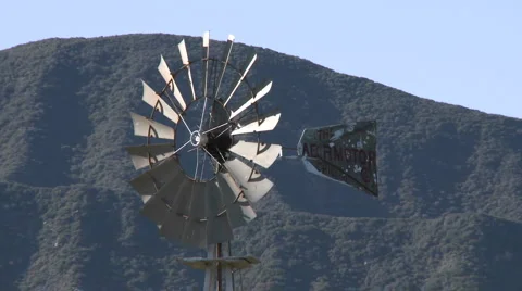 Spinning windmill drawing water from a well in Ojai, California. Stock Footage 1034393