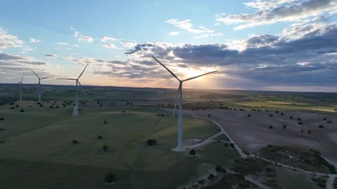 Spinning windmills with the sun behind them hidden in the clouds Stock Footage 274192687
