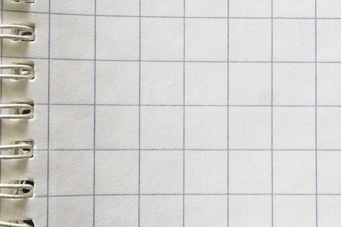 A spiral-bound notebook page with a grid pattern. Stock Photos