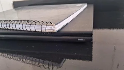 Spiral bound notebook resting on top of a closed black laptop Stock Photos