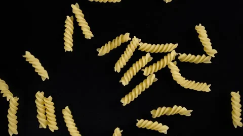 Spiral fusilli paste, a handful falls on a black background. Stock Footage 276836259