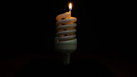 Spiral Light Bulb With Candle Inside on Black Background. Blackout Concept Stock Footage 320906251