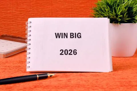 A spiral notebook displaying Win Big 2026 rests on a patterned orange surface Stock Photos