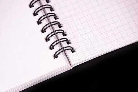 Spiral notebook with grid pages, white paper, black binding, clean compositio Stock Photos