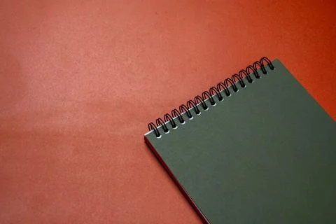 A spiral notebook is on a red background Stock Photos