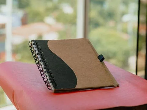 Spiral notebook on red folder with natural light and blur background Foto stock