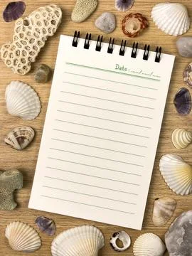 Spiral notebook with seashells and corals on wooden background Stock Photos