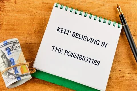 A spiral notepad boldly displays an uplifting message encouraging belief in p Stock Photos
