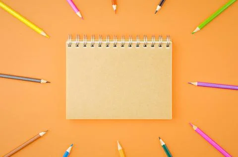 Spiral notepad with colored pencils. Stock Photos