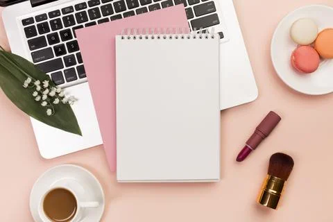 Spiral notepad laptop with macaroons coffee cup with makeup brushes colored.. Stock Photos