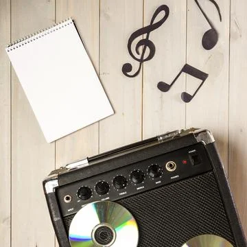 Spiral notepad musical note amplifier with compact disc wooden desk Stock Photos