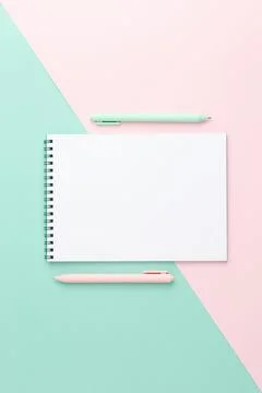 Spiral notepad with pens on two colour background. Stock Photos