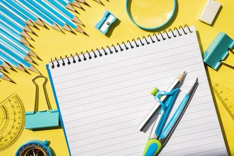 Spiral notepad with pens on yellow background. Back to school stationery flat Stock Photos