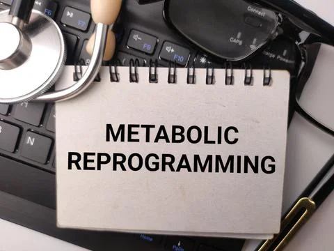 A spiral notepad reading METABOLIC REPROGRAMMING lies with a stethoscope, c.. Stock Photos