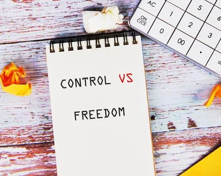 A spiral notepad shows control versus freedom in bold black and red letters. It Stock Photos