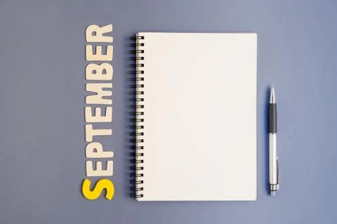 Spiral open notebook with pen and September month wording Stock Photos