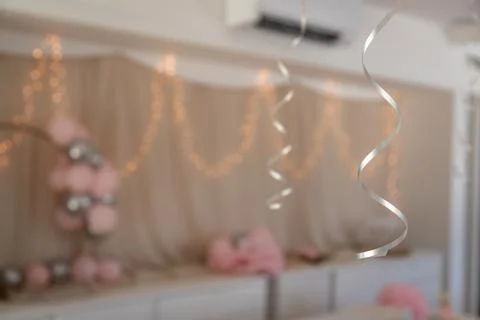 Spiral ribbon in the foreground frames a blurred pastel party backdrop Stock-Fotos