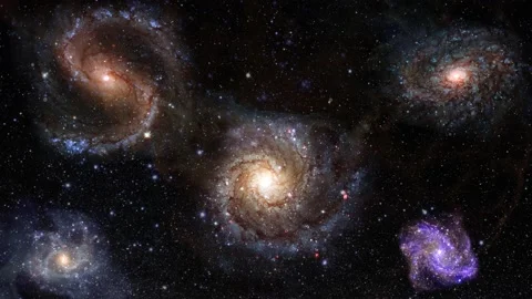 Spiral rotating galaxies in deep space. Flying through interstellar space into Stock Footage 147600064