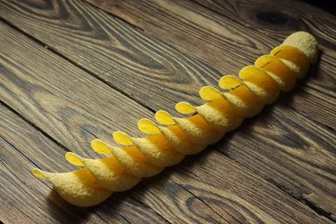 Spiral Stack of Yellow Potato Chips on Wood 库存照片