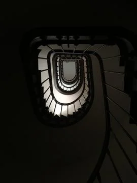 Spiral staircase in shadow Stock Photos