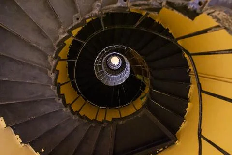 A spiral staircase winds downward inside the Sanganeb reef lighthouse, Red .. Stock Photos