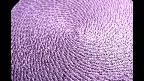 Spiral woven pattern made from rough fibers forms tight circular loops. Natural Stock Photos