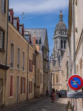 The spire of Église Saint-Benoît at the end of a narrow cobbled street Stock Photos
