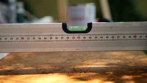 Spirit bubble level tool with ruler measuring the horizontal surface of plywood Stock Footage 156687105