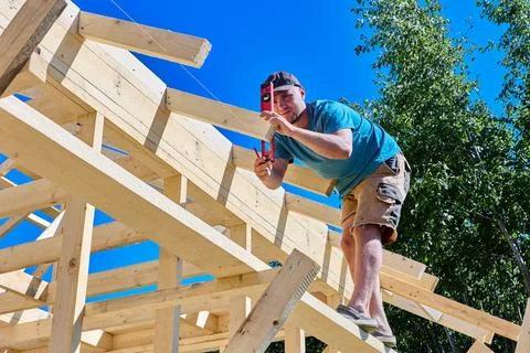 Spirit level checking vertical alignment of timber framing as carpenter mea.. Stock Photos