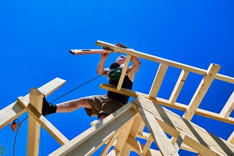 Spirit level used by construction worker to check rafter alignment, with ci.. Stock Photos