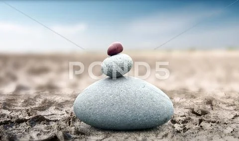 Spiritual and peaceful rock pebble tower on dry deserted land zen like concept Stock Photos