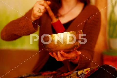 Spiritual girl immersed in meditative sounds of tibetian bowl. Stock Photos