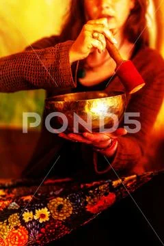 Spiritual girl immersed in meditative sounds of tibetian bowl. Stock Photos