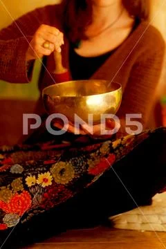 Spiritual girl immersed in meditative sounds of tibetian bowl. Stock Photos