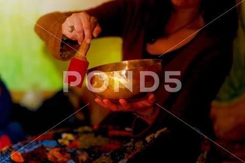 Spiritual girl immersed in meditative sounds of tibetian bowl. Stock Photos