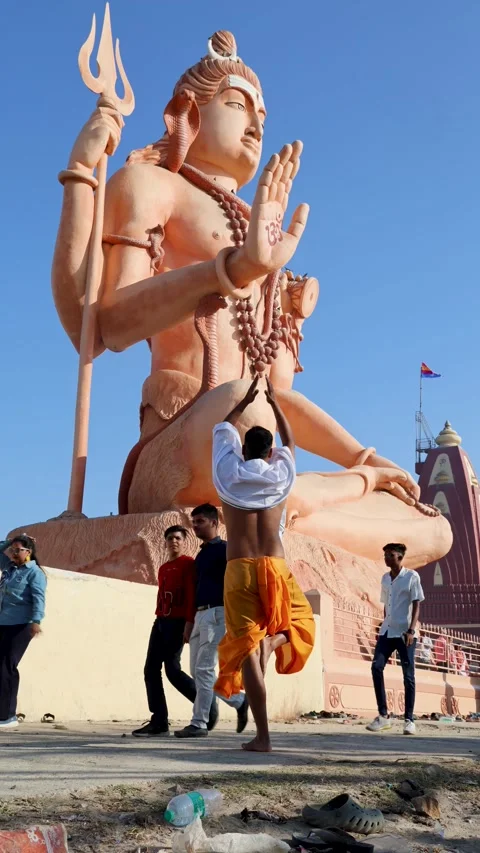 Spiritual moment of man devotee offering salutation to huge shiva idol with 库存影片 321880152