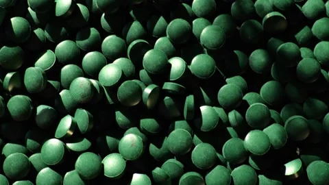 Spirulina tablets background in the suns rays.Algae food supplement Stock Footage 317403180