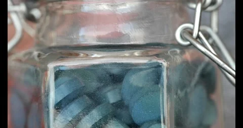 Spirulina tablets. Fingers take spirulina tablet from jar. Stock Footage 274093553