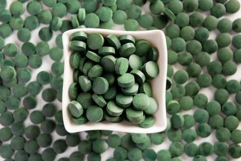 Spirulina tablets on white background. Flat lay. Stock Photos