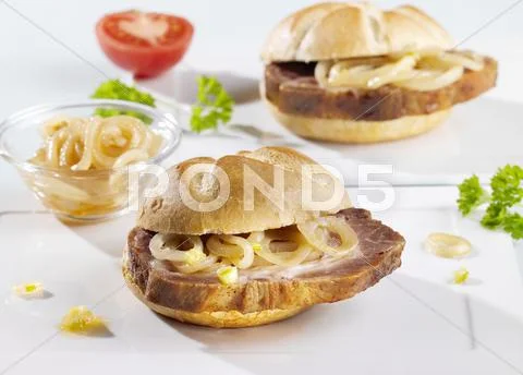 Spit-roasted meat and onions in bread rolls Stock Photos