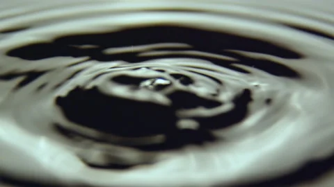 Splash from big raindrops making round circles on surface Stock Footage 236577934