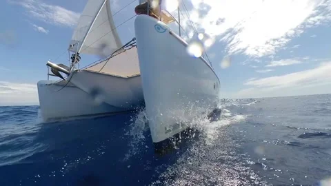 Splash on the bow of a catamaran sailboat in speed - Close-up shot over the sea Stock Footage 133464729